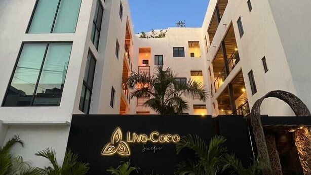 A modern building with a sign reading 'Live-Coco.' - Coco Live Suites (Playa del Carmen)