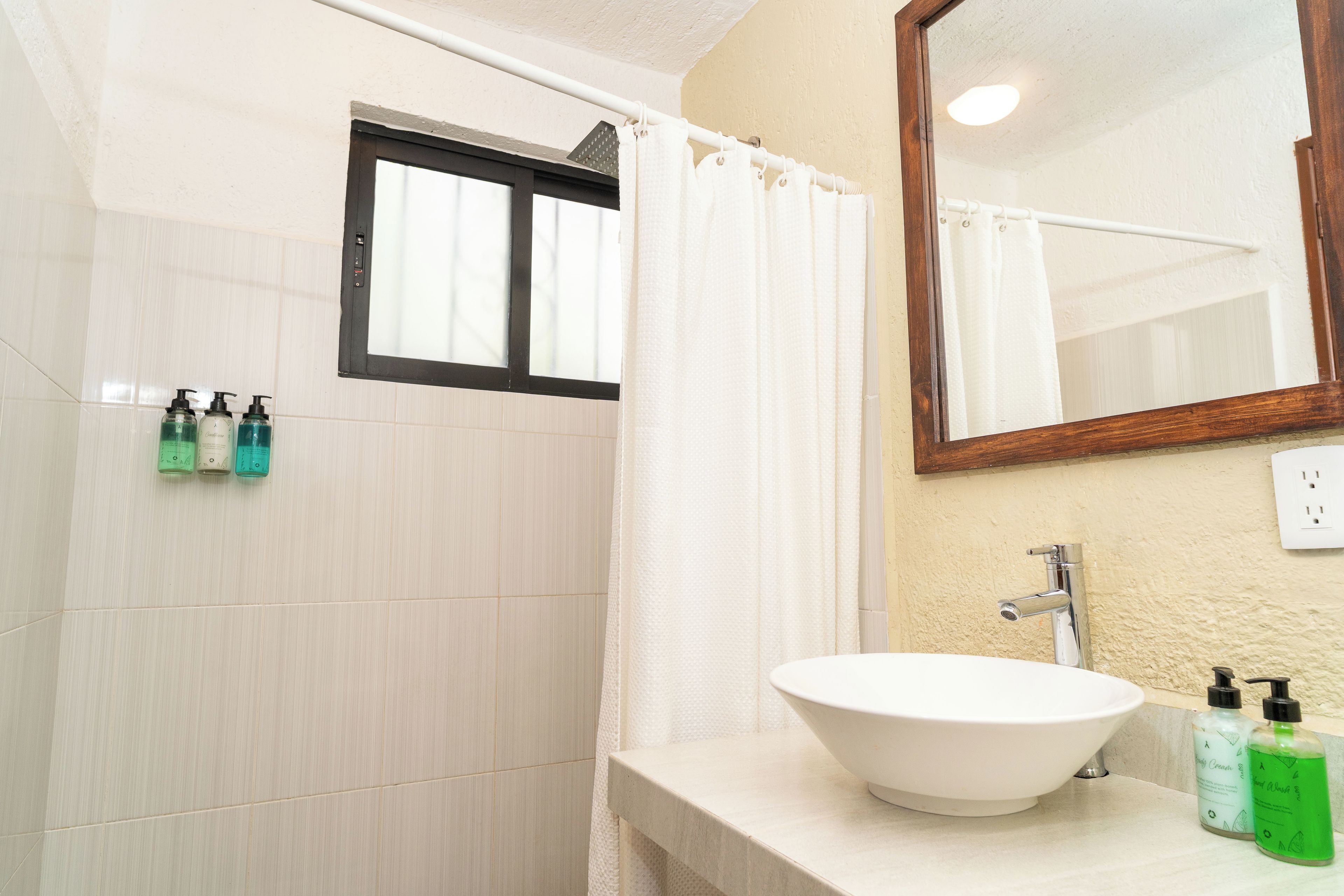 A bathroom with a white sink, a mirror, and a shower curtain.