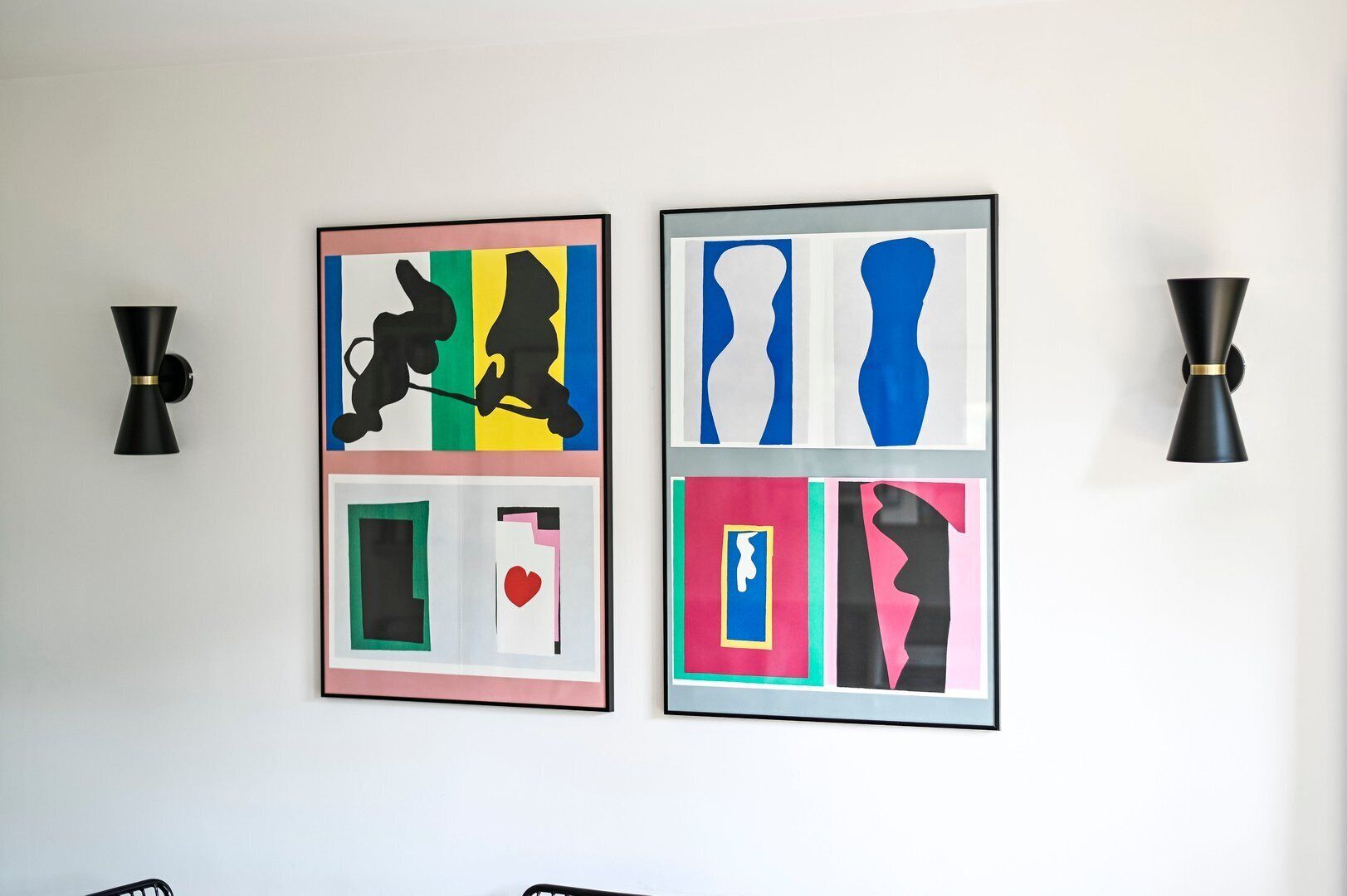 Two abstract art pieces on a white wall, each framed in black.