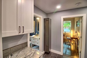 Una cocina moderna con encimeras de granito, horno empotrado y comedor con mesa y sillas.