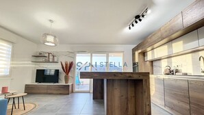 Une cuisine moderne avec des meubles en bois, un four encastré et un grand îlot central.