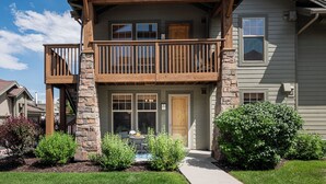 A two-story house with a balcony, stone pillars, and a front door. - 2BR Cozy Getaway Awaits with High-Speed Wi-Fi! (Park City)