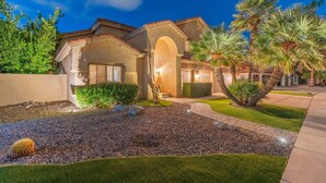 A residential property with a landscaped garden, a patio, and a well-maintained lawn. - Sunset Paradise l Waterslide l Heated Pool l Hot Tub l Putting Green (Scottsdale)