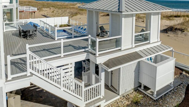 A multi-level beach house with a deck, outdoor seating, and a view of the ocean. - Royal Shell North | Oceanfront | Private Pool and Hot Tub (Virginia Beach)