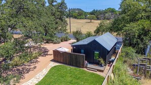 A modern house with a metal roof, surrounded by a well-maintained lawn and a stone pathway.