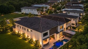A modern residential complex with multiple houses, a swimming pool, and well-maintained lawns. - The Immersive Estate at Reunion - Theme Park Inside Your Vacation Home (Kissimmee)