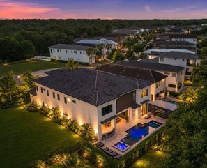 A modern residential complex with multiple houses, a swimming pool, and well-maintained lawns.