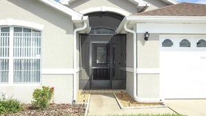 Una casa residenziale con un portone d'ingresso, un garage e un piccolo giardino.