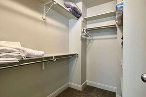 Une petite salle de bain fermée, équipée d’un porte-serviettes, d’une étagère avec un oreiller et d’une porte.