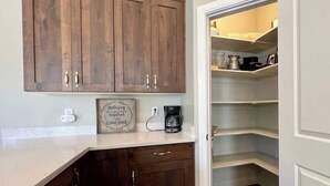 Een keuken met houten kastjes, een koffiezetapparaat en een lijst.