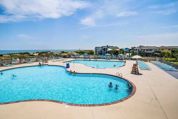 Relax by the multi-tiered pool, featuring lounge chairs and sunbeds.