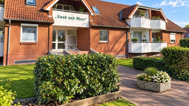 A two-story residential building with a sign reading 'Land und Meer' and the number 177.