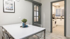 A modern kitchen with white cabinets, a built-in oven, and a window with frosted glass.
