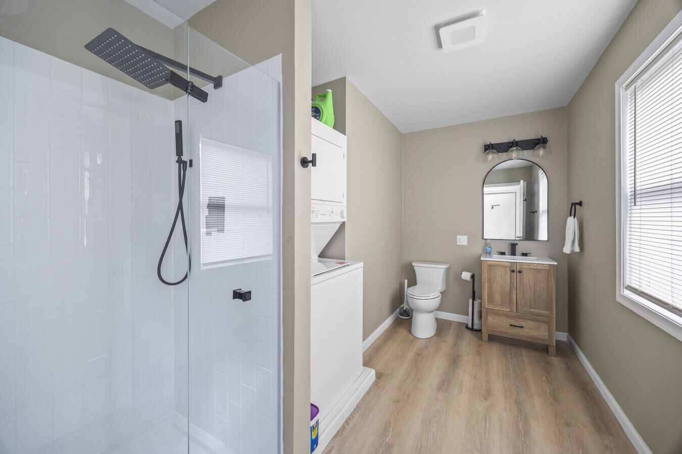 Une salle de bain moderne dotée d’une douche à parois de verre, de toilettes et d’un meuble-lavabo avec un miroir.