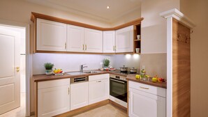 A modern kitchen with white cabinetry, wooden countertops, a built-in oven, and a sink.