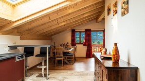 A cozy kitchen with a skylight, wooden ceiling, and a dining area with a view. - Ferienwohnung Jennerblick, 85 qm, 1-4 Personen, 2 Separate Schlafzimmer, Wohn- Esszimmer, Bad, Balkon (Schönau am Königssee)