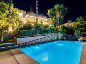 Ein Pool mit einer Steinmauer und Stufen, die zu einem Gebäude führen.