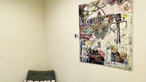 A room with a gray armchair and a colorful abstract painting on the wall. - Downtown Bend Vacation Cottage (Bend)
