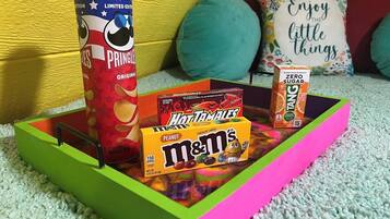 Una bandeja con bocadillos que incluyen Pringles, Hot Tamales y M&M's.