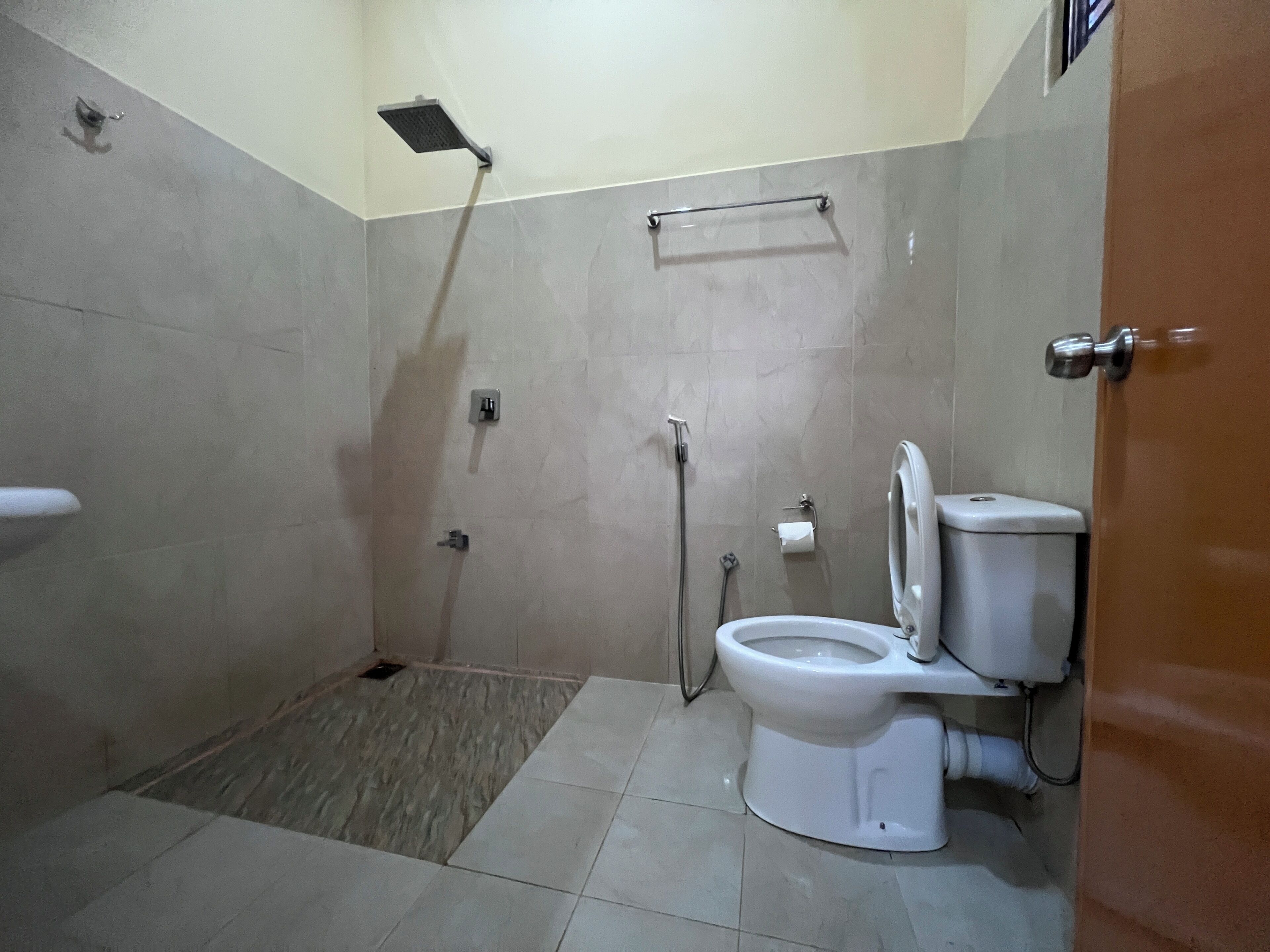 A bathroom with a shower, toilet, and a towel rack.