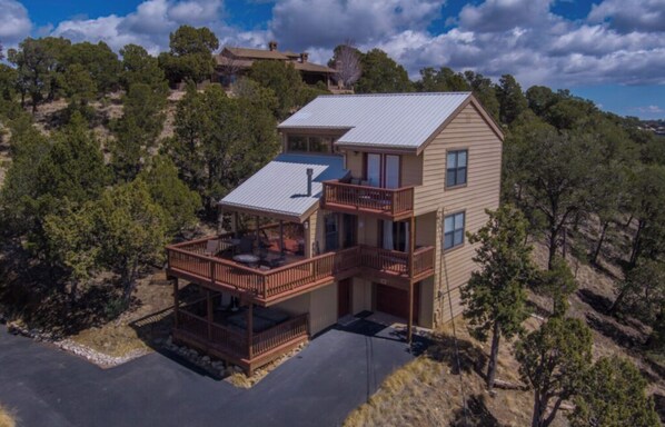A two-story house with a balcony and a covered patio area.