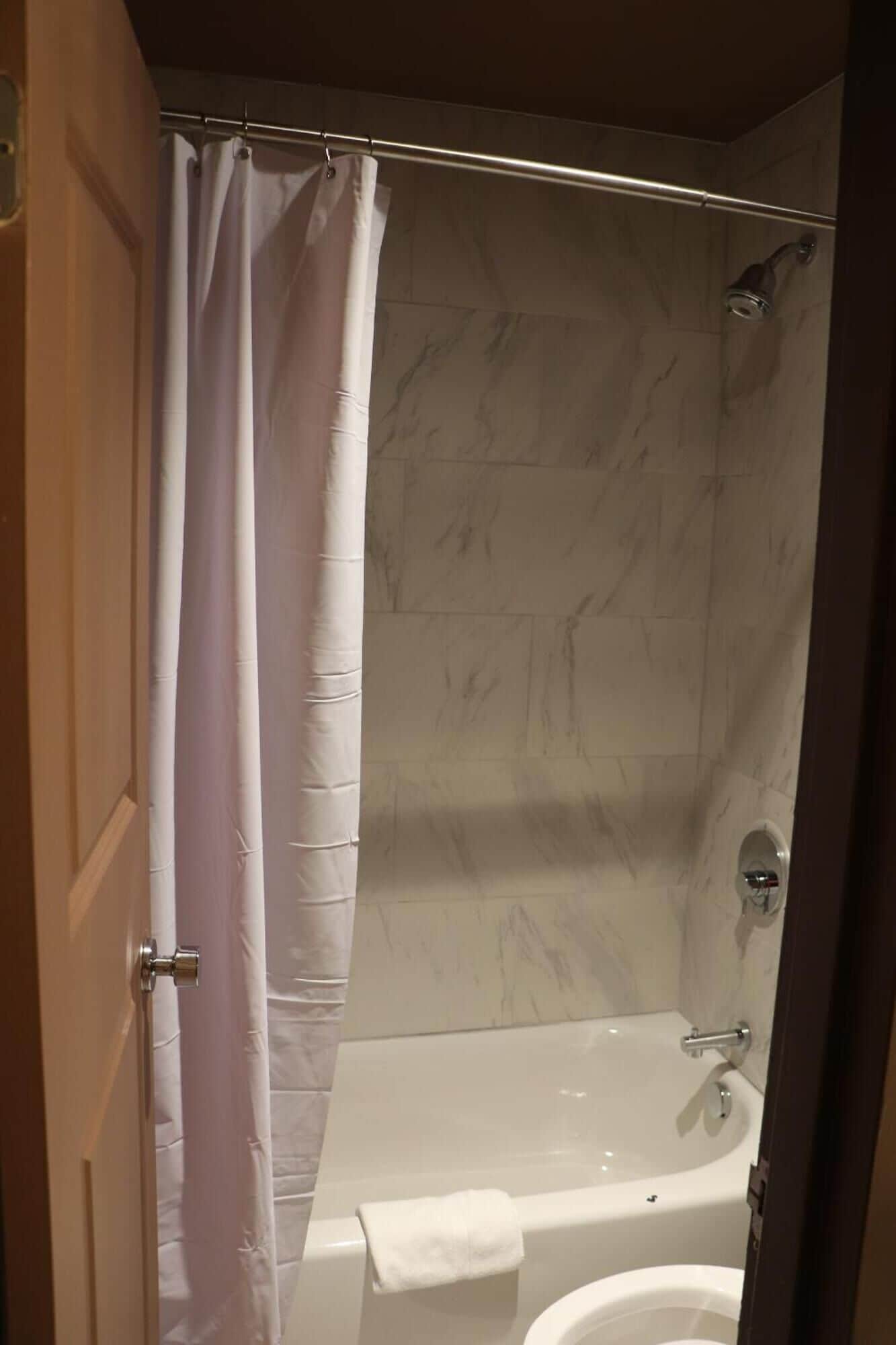 A bathroom with a shower, a bathtub, and a toilet.