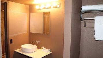 Une salle de bain avec un lavabo blanc, un miroir et un porte-serviettes.