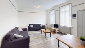 A modern living room with a sofa, a coffee table, and a TV stand. - City Centre-University Home from Home (Sunderland)