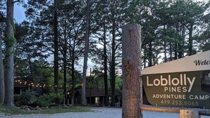 Une enseigne indiquant le « Camp d’aventure Lobolly Pines », avec un numéro de téléphone à contacter.