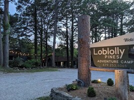 Señal para el campamento de aventuras Lobolly Pines con un número de contacto.