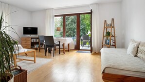 Een kamer met een bed, een bureau met stoel, een televisie en een boekenplank.