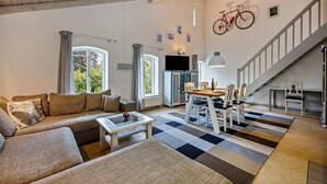 Una sala de estar con sofá, mesa de centro y comedor con sillas y mesa.