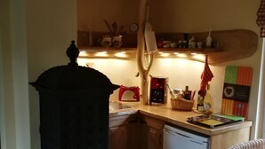 A kitchen with a wood-burning stove, a refrigerator, and a sink. - Holiday Home 'Jagdhaus Franz' with Terrace (Kloster Lehnin)