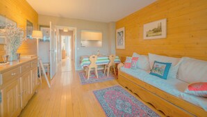A cozy room with a wooden floor, a sofa, a dining table with chairs, and a cabinet. - Apt Du Golf Du Mont d'Arbois in Megeve, near ski lift, Megeve (Chamonix), France (Megeve (Chamonix))