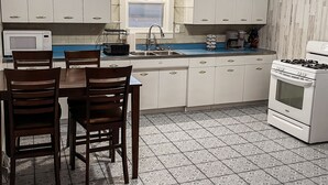 A kitchen with white cabinets, a stove, a sink, and a window. - Freshly Updated house near Wilson Lake, Kansas’s nicest lake!!! (Lucas)