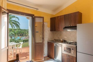 Une cuisine compacte avec des meubles en bois, un four encastré et une cuisinière à gaz.