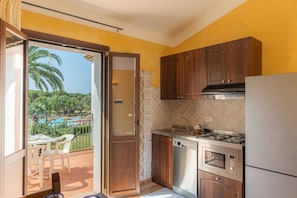 A compact kitchen with wooden cabinets, a built-in oven, and a gas stove.