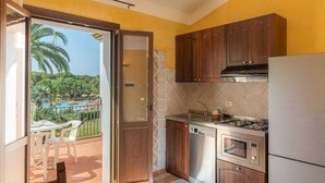 A compact kitchen with wooden cabinets, a built-in oven, and a gas stove.