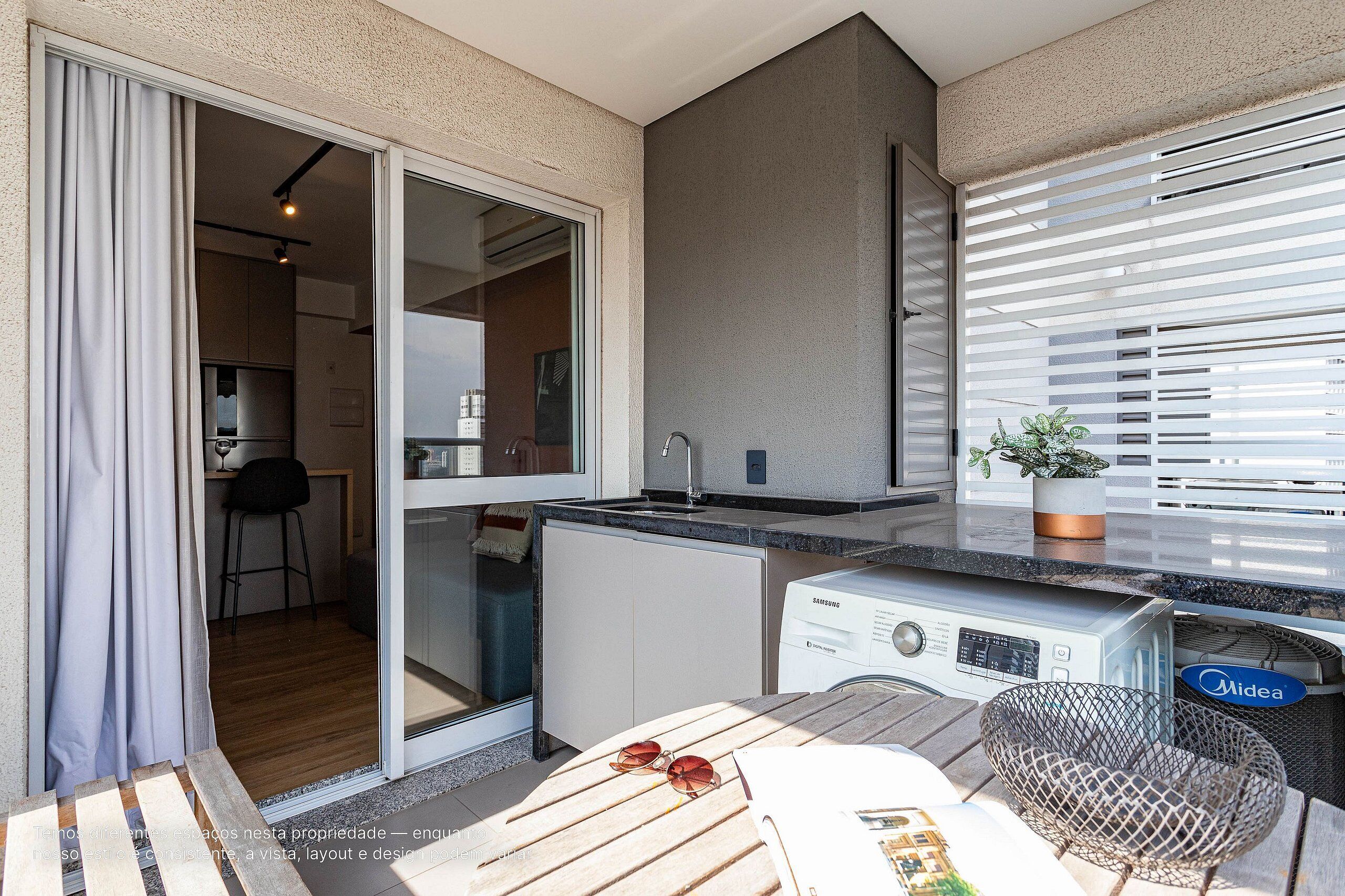 A modern kitchen with a built-in dishwasher, a dining area with a table and chairs, and a sliding glass door leading to a balcony.