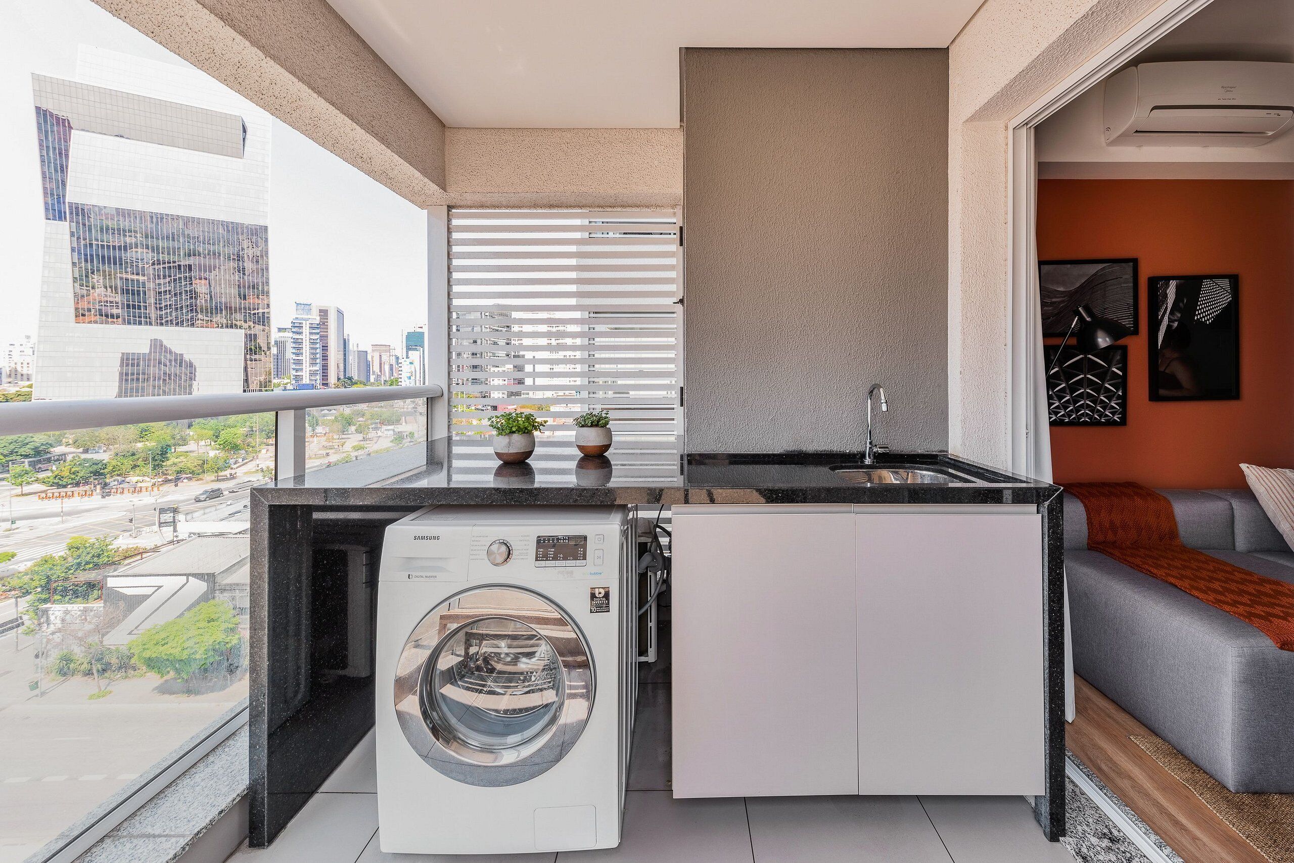 A compact kitchen with a washing machine, a sink, and a small countertop.