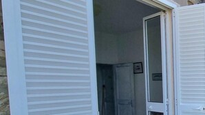 A room with a bed, a door, and a window.