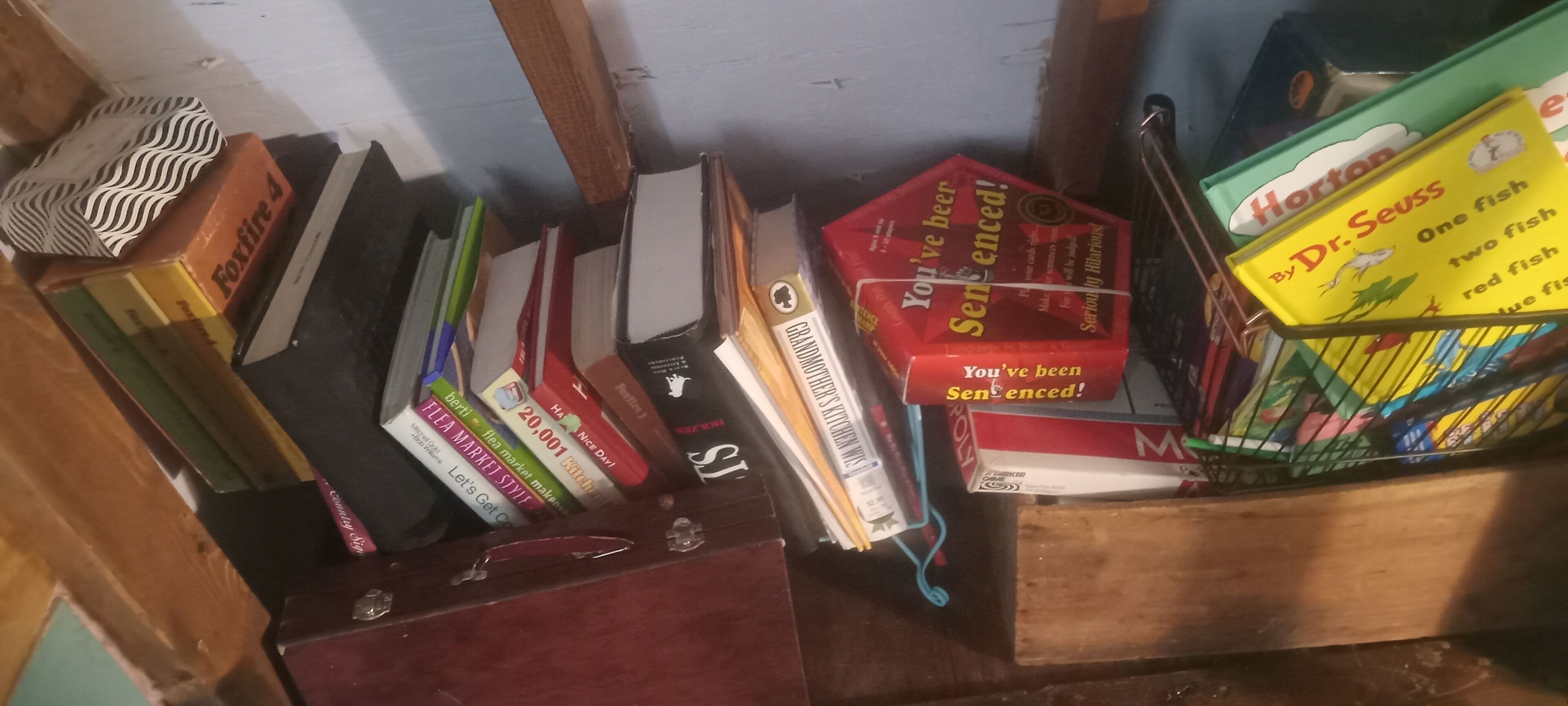 En bokhylla med en samling böcker och en låda med böcker av Dr. Seuss.