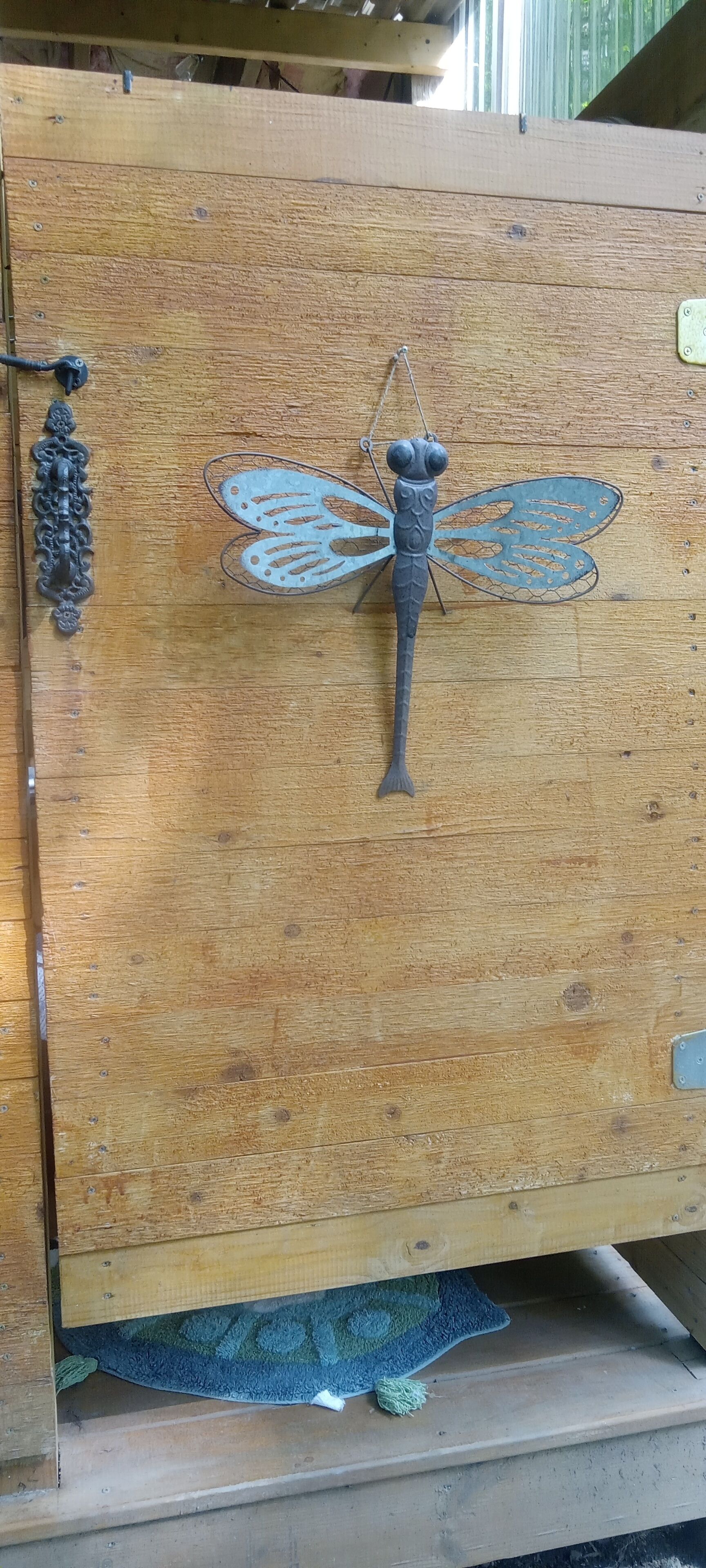 Et træskab med en metaldragonfly-dekoration.