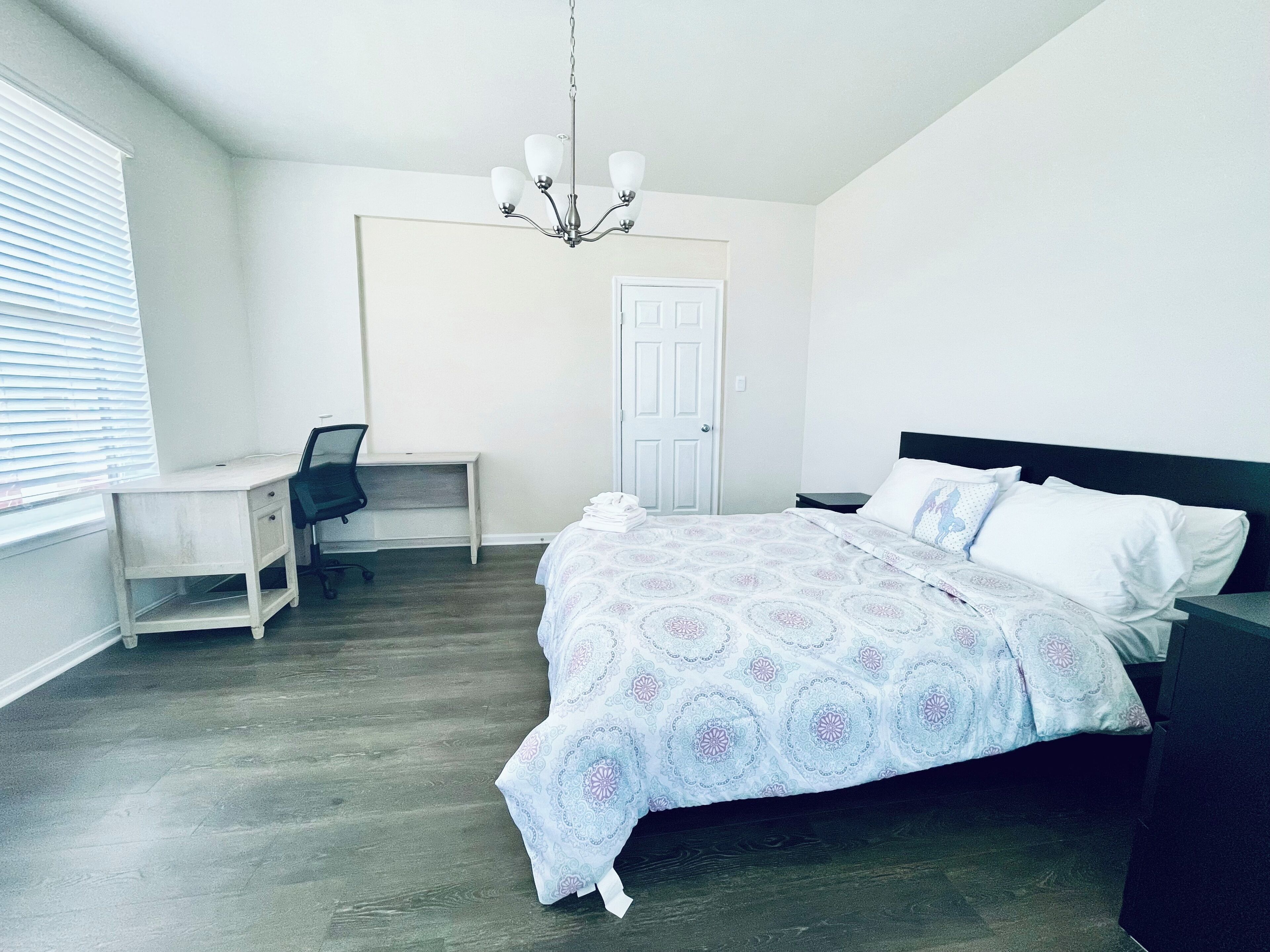 Une chambre à coucher avec un lit, un bureau et une chaise.