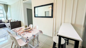 Een eetgedeelte met een tafel gedekt voor twee personen, een bank en een spiegel aan de muur.