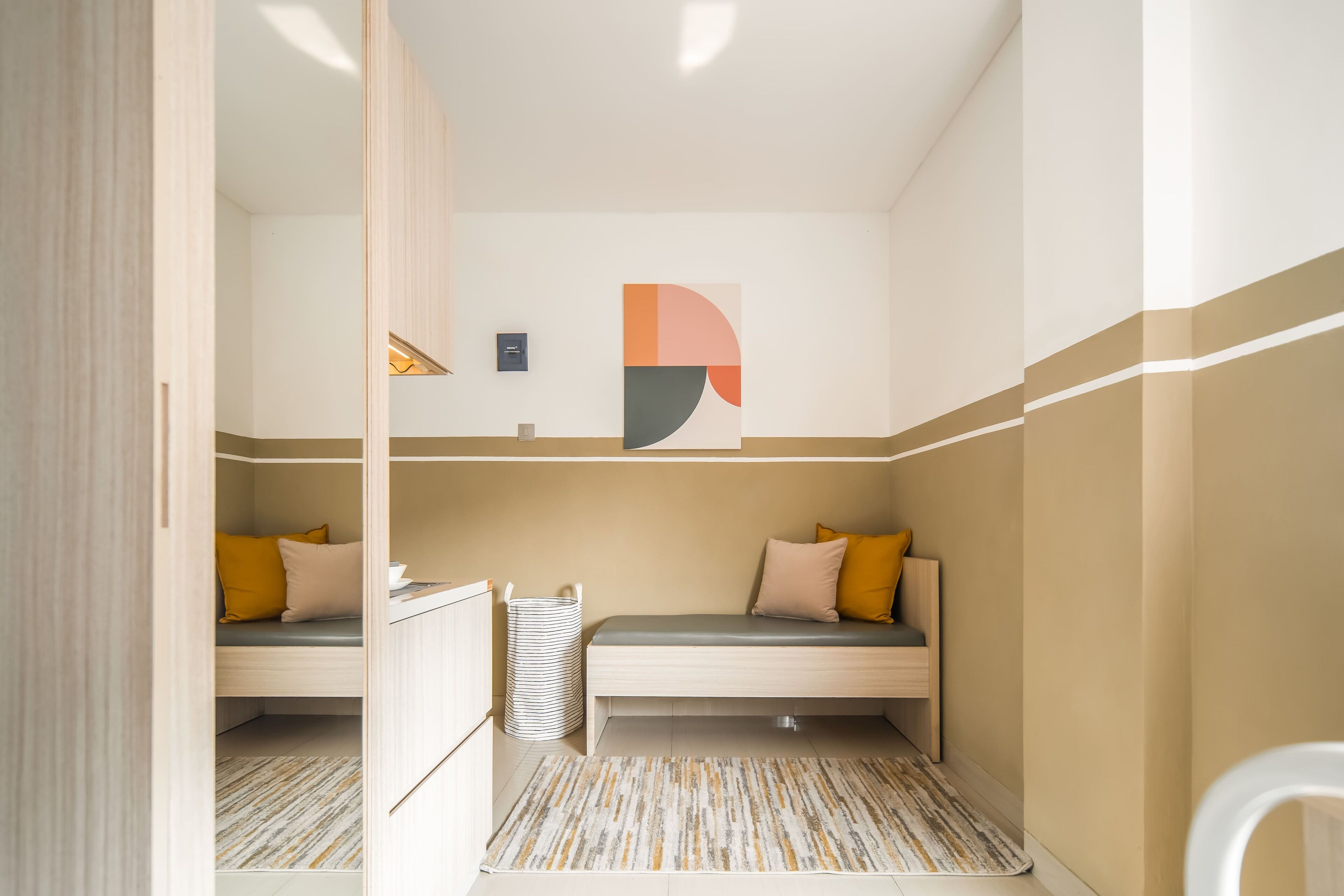 Ein kleines Zimmer mit zwei Etagenbetten, einem kleinen Schreibtisch und einem Mülleimer.