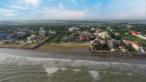 An aerial view of a coastal city with buildings, a beach, and a river. - Royal Gitanjali Resort &Spa (Kanthi)