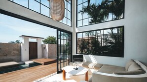 Un espacio exterior moderno con piscina, zona de estar y ventanas amplias que ofrecen vistas del paisaje circundante.