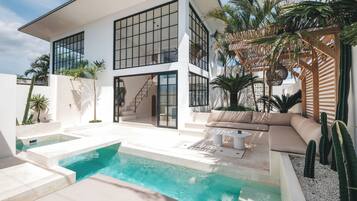 A modern house with a swimming pool, outdoor seating, and a pergola.