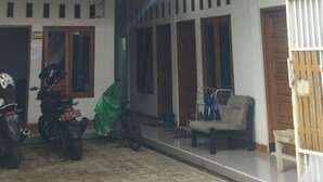 A spacious indoor area with a tiled floor, multiple windows, and a balcony. - Hotel O Penginapan Hj Lilis Syariah (Sukabumi)